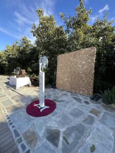 Open air photo booth on a garden patio beside a gold sequin backdrop